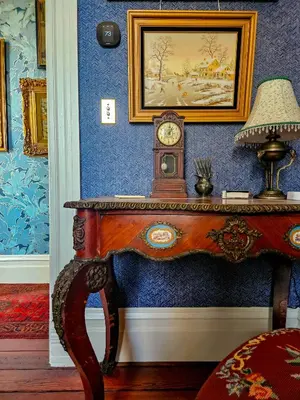 a table with a clock on a blue wall at The JD Hyde Historic Inn in Visalia