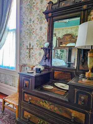 a bedroom with a dresser with a mirror on it at The JD Hyde Historic Inn in Visalia