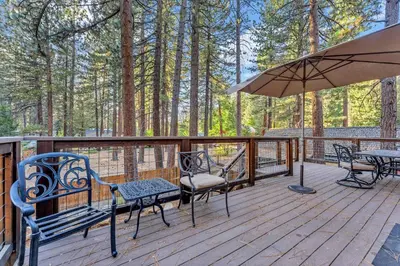 a deck with a table and chairs and an umbrella at Kings Beach Retreat, Hot Tub, Walk to Beach in Kings Beach