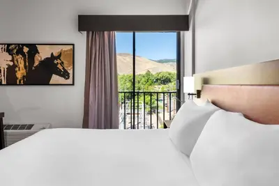 a bedroom with a bed and a window with a view at The Federal Hotel Downtown Carson City, an Ascend Collection Hotel in Carson City
