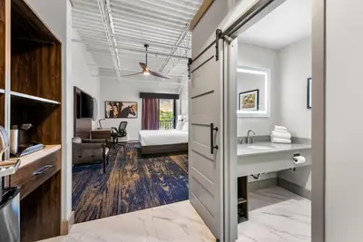 a bathroom with a sink and a bedroom at The Federal Hotel Downtown Carson City, an Ascend Collection Hotel in Carson City