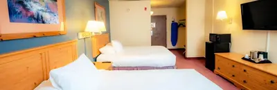 a hotel room with two beds and a flat screen tv at The Federal Hotel Downtown Carson City, an Ascend Collection Hotel in Carson City