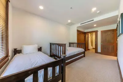 a bedroom with two beds and a hallway at Iron Horse Lodge South 408 by East West Hospitality in Truckee