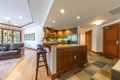 a kitchen with a bar and a living room at Iron Horse Lodge South 408 by East West Hospitality in Truckee
