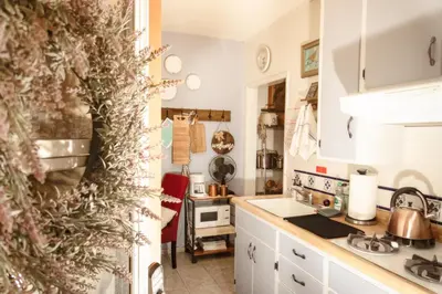 a kitchen with white cabinets and a christmas tree at 1 BR Orchard Cottage - Gateway to Two National Parks! in Visalia