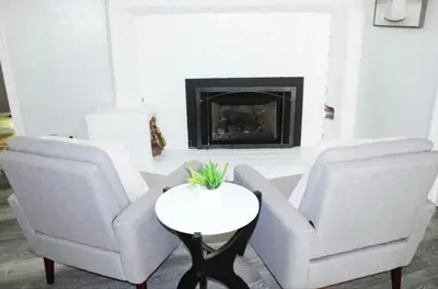 two chairs and a table in a living room with a fireplace at Beautiful Home & Pool in Fresno
