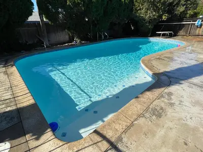 a swimming pool with blue water in a yard at Beautiful Home & Pool in Fresno