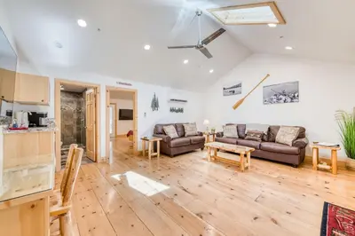 a living room with two couches and a table at Cottage Like Suite with Private Hot Tub in Bass Lake