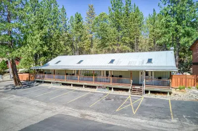 a building with a metal roof in a parking lot at Cottage Like Suite with Private Hot Tub in Bass Lake