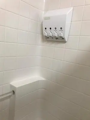 a white tiled bathroom with a toilet and a thermost at Serenity Pines in Yosemite West