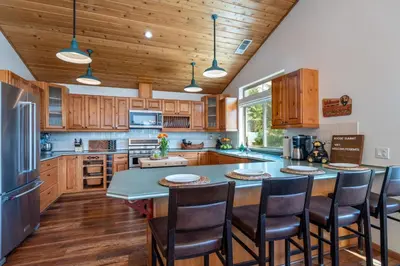 a kitchen with wooden cabinets and a table with chairs at Yosemite Summit & Little Summit in Yosemite West