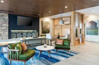 a lobby of a hotel with chairs and a table at Fairfield Inn & Suites Hanford in Hanford