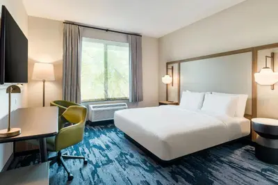 a hotel room with a bed and a desk at Fairfield Inn & Suites Hanford in Hanford
