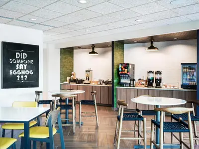 a restaurant with tables and chairs and a counter at Fairfield Inn & Suites Hanford in Hanford