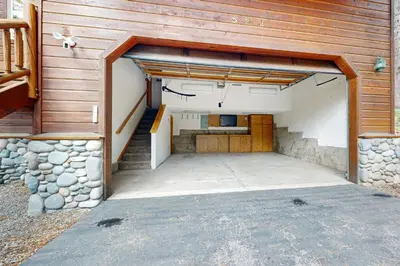 an open garage with stairs and a stone wall at Vista Pines Retreat in Tahoe Vista