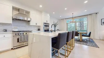 a kitchen with white cabinets and a table with chairs at Timbers #12 townhouse in Mammoth Lakes