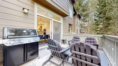 a patio with a stove and chairs on a deck at Timbers #12 townhouse in Mammoth Lakes