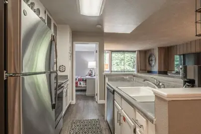 a kitchen with a stainless steel refrigerator and a sink at Crestview Bldg A #49 - Spacious 2 Bedroom, 2 Bathroom, Sleeps 7 - Close to Canyon Lodge and Village in Mammoth Lakes