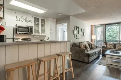 a kitchen and living room with a couch and a table at Crestview Bldg A #49 - Spacious 2 Bedroom, 2 Bathroom, Sleeps 7 - Close to Canyon Lodge and Village in Mammoth Lakes