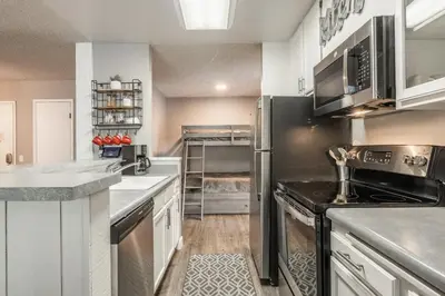 a kitchen with white cabinets and a black refrigerator at Crestview Bldg A #49 - Spacious 2 Bedroom, 2 Bathroom, Sleeps 7 - Close to Canyon Lodge and Village in Mammoth Lakes