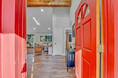 a hallway with a red door and a living room at Bright Tahoe Home with Private Backyard Near Beach in Tahoe City