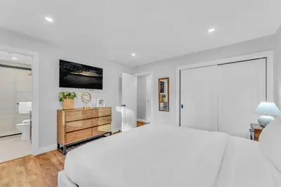 a white bedroom with a large bed and a bathroom at Bright Tahoe Home with Private Backyard Near Beach in Tahoe City