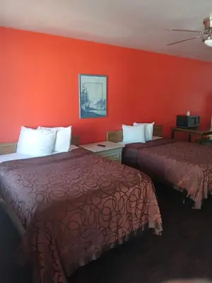two beds in a hotel room with red walls at Coalinga Motel in Coalinga