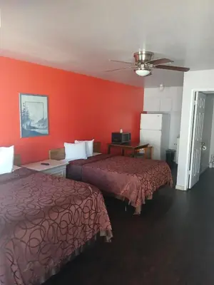two beds in a hotel room with red walls at Coalinga Motel in Coalinga