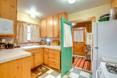 a kitchen with wooden cabinets and a green door at 1 Mi to Lake Tahoe Rustic Cabin with Boat Dock in Tahoma