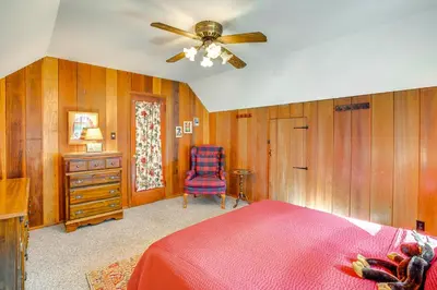 a bedroom with a bed and a chair and a ceiling fan at 1 Mi to Lake Tahoe Rustic Cabin with Boat Dock in Tahoma