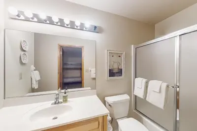 a bathroom with a sink and a toilet and a mirror at Tranquil Pines Retreat in Shaver Lake