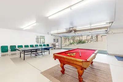 a room with a pool table and some green chairs at Tranquil Pines Retreat in Shaver Lake