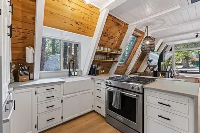 a kitchen with white cabinets and a stove top oven at The Sugar Pine Speakeasy in Homewood