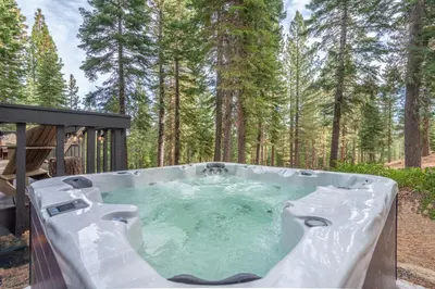 a hot tub in the middle of a forest at Mid Century Modern A-Frame Cabin at Northstar in Truckee