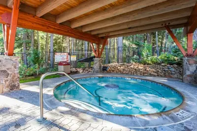 a hot tub in a patio with a wooden roof at Mid Century Modern A-Frame Cabin at Northstar in Truckee