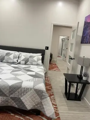 a bedroom with a bed and a table with a lamp at Muniz Village in Three Rivers