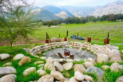 a rock garden with a pond in a field at Muniz Village in Three Rivers