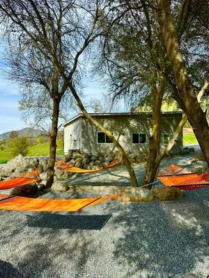 a building with trees and orange barricades in a parking lot at Muniz Village in Three Rivers