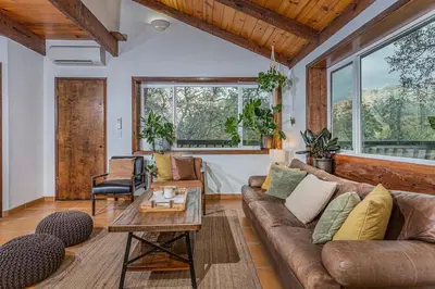a living room with a couch and a table at Sequoia TREE HOUSE light andbright in Three Rivers