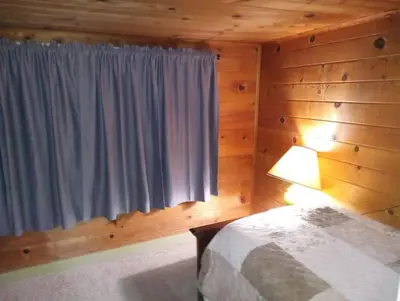 a bedroom with a bed and a window with a lamp at Baltyr Cabin in Miramonte