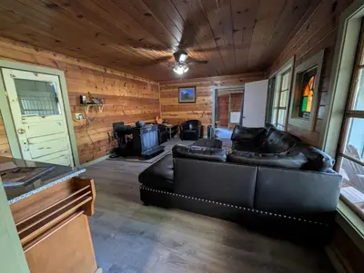 a living room with a black leather couch in a room at Baltyr Cabin in Miramonte