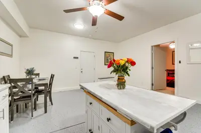 a kitchen with a ceiling fan and a table with flowers at 10 Mi to Yosemite Lake Atwater Retreat in Atwater