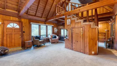 a large room with wooden walls and a staircase in a house at Riversong Lodge by AvantStay Sauna Hot Tub On The Truckee River in Truckee