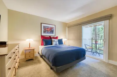 a bedroom with a large bed and a balcony at Carnelian Woods # 57 - 3 BR 2 BA Pet Friendly With HOA Amenities in Carnelian Bay