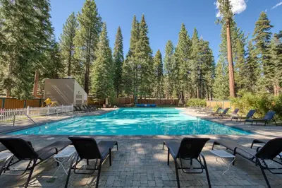 a large swimming pool with chairs and trees at Carnelian Woods # 57 - 3 BR 2 BA Pet Friendly With HOA Amenities in Carnelian Bay