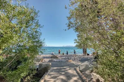 a wooden path leading to a beach with people on it at Carnelian Woods # 57 - 3 BR 2 BA Pet Friendly With HOA Amenities in Carnelian Bay
