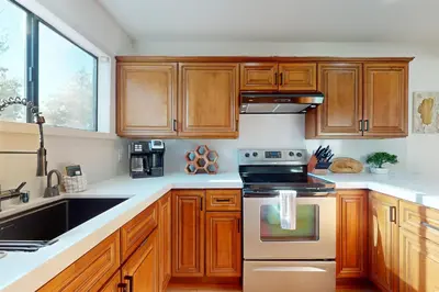 a kitchen with wooden cabinets and a stove top oven at Keys to Paradise in South Lake Tahoe