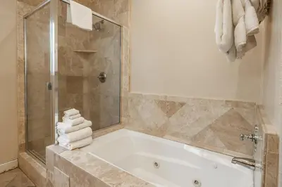 a bathroom with a tub and a shower with towels at Mammoth Gateway Village #1 - Highly Updated Townhome - Walk To Village 3 Bed+Loft, Sleeps 10 in Mammoth Lakes