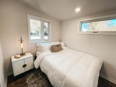 a small bedroom with a white bed and a window at Beautiful and Elegant River Front Cottage in Reno