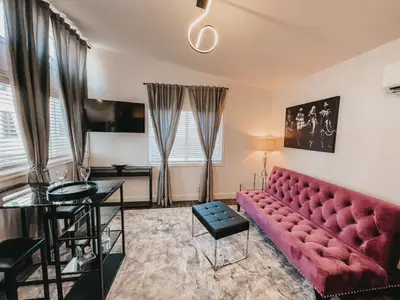a living room with a red couch and a table at Beautiful Courtyard Cottage Amethyst in Reno